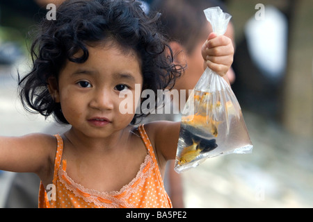 Enfant vietnamien tenant un sac d'animal poisson pêché dans la rivière Saigon à Ho Chi Minh City Vietnam Banque D'Images