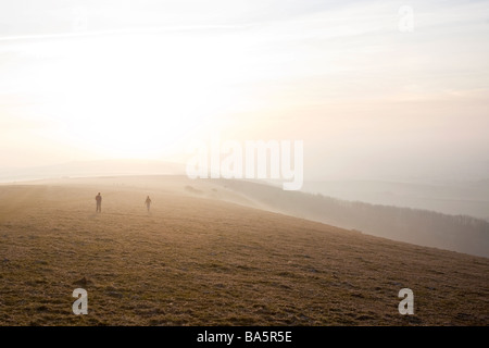 Deux randonneurs sur les South Downs juste avant le coucher du soleil. Près de 1 156 km, East Sussex, England, UK Banque D'Images