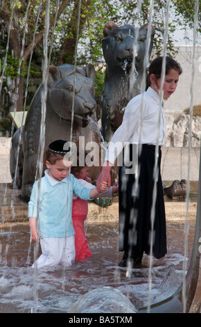 Israël Jérusalem fontaine aux Lions d'enfants juifs orthodoxes pagayer dans l'eau Banque D'Images