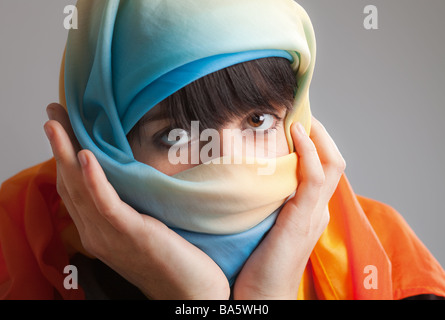 Fille en foulard holding her head Banque D'Images