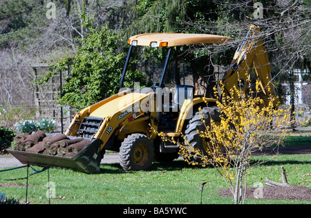 Un tracteur jaune avec une benne de chargement de gazon fraîchement coupé. Banque D'Images