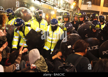 La police est la dispersion avec force les gens au G20 de démonstration dans le centre de Londres à l'aide de protections court pour frapper et pousser les gens Banque D'Images