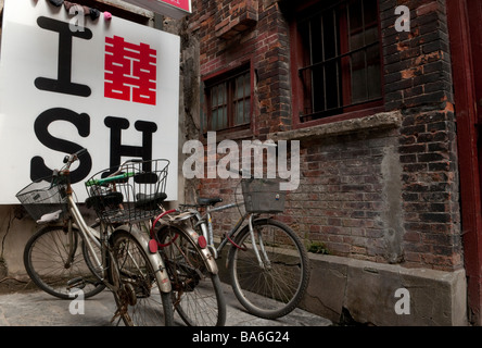 Bicyclettes garées en face d'un J'aime Shanghai signer dans une ruelle à Shanghai Chine Banque D'Images