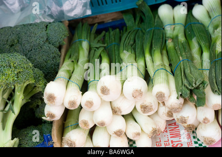 Légumes frais, y compris le brocoli et les oignons de printemps à vendre sur un marché dans une ville anglaise. Banque D'Images