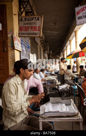 Un notaire greffier types de documents sur une machine à écrire dans la rue dans la vieille ville de Delhi à l'extérieur des bureaux d'avocats. Banque D'Images