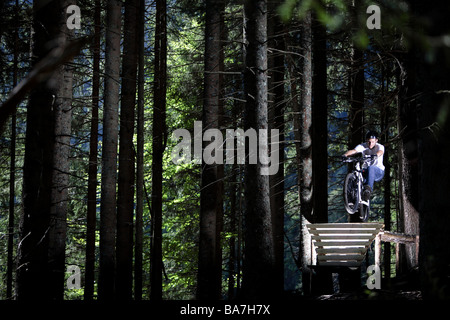 Jeune homme monté sur un VTT en forêt, Oberammergau, Bavière, Allemagne Banque D'Images