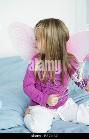 Girl (3-4 ans) portant des ailes de papillon holding baguette, Munich, Allemagne Banque D'Images