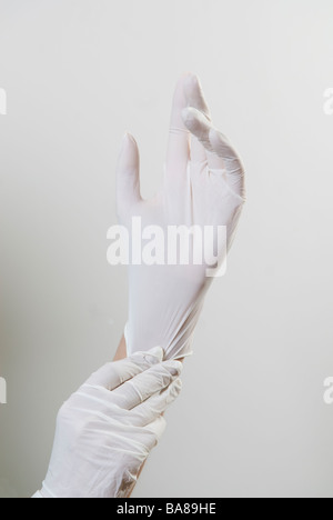 Les mains du médecin portant des gants chirurgicaux en caoutchouc blanc Banque D'Images