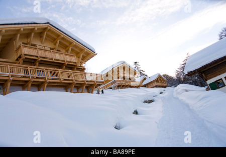 Scène d'hiver de la neige a couvert des chalets de ski dans un centre de ski alpin. Banque D'Images