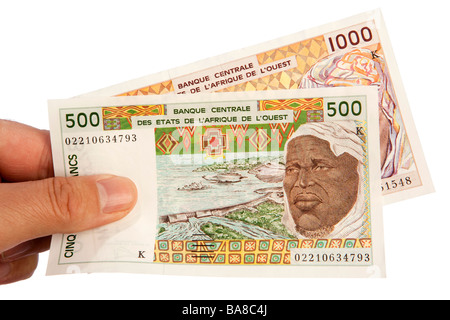 De l'argent homme hand holding poignée de monnaie CFA sénégalais Banque D'Images