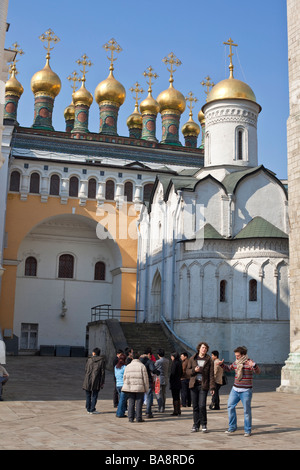 Un groupe de touristes en face de l'église de la déposition de la Robe à côté de dômes dorés des Palais Terem, Kremlin, Moscou Banque D'Images