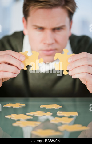 Businessman looking at des pièces de puzzle Banque D'Images