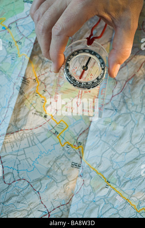 Man holding compass sur la carte Banque D'Images