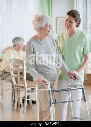 Nurse helping senior woman in walker Banque D'Images