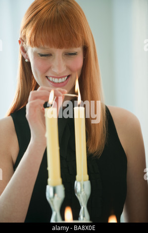 Femme de l'éclairage des bougies Banque D'Images