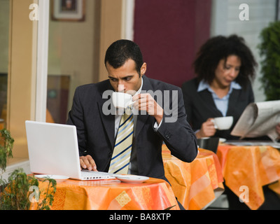 Businessman looking at laptop at outdoor cafe Banque D'Images