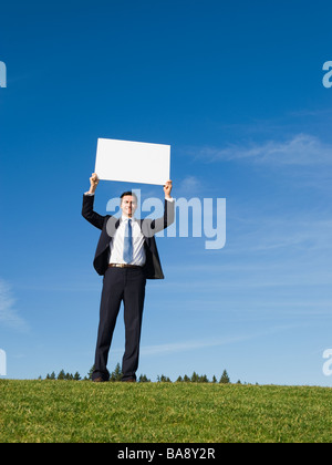 Businessman holding blank sign Banque D'Images