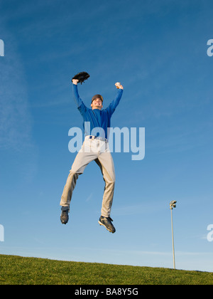 Joueur de baseball sauter dans l'air Banque D'Images