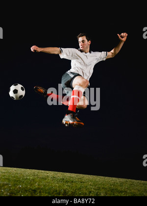 Soccer player kicking ball Banque D'Images