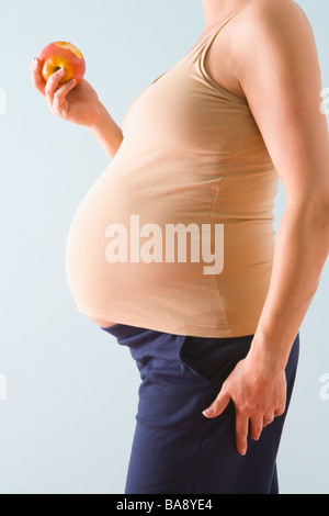Pregnant woman eating apple Banque D'Images