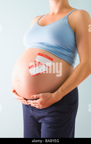 Femme enceinte avec nom tags sur ventre Banque D'Images