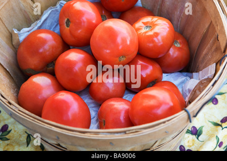 Les tomates dans un panier à un stand de fruits Banque D'Images