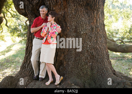 Couple standing next to tree in park Banque D'Images