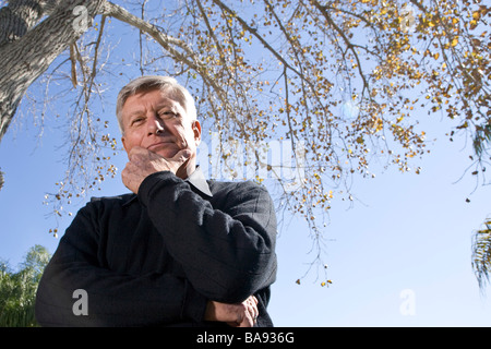 Portrait of senior man standing under tree in garden, Close up Banque D'Images