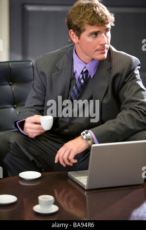 Businessman with laptop ayant tasse de café Banque D'Images
