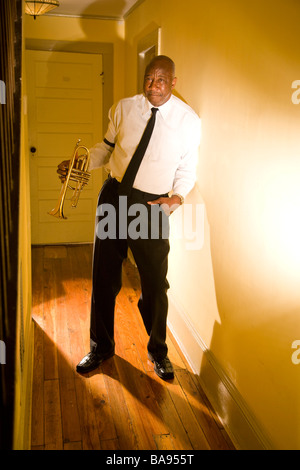 Senior African American musicien de jazz debout dans le couloir avec trompette Banque D'Images