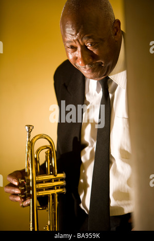 Senior African American musician holding Trumpet in hallway Banque D'Images