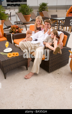 Deux enfants avec le père de détente sur terrasse sur le toit Banque D'Images