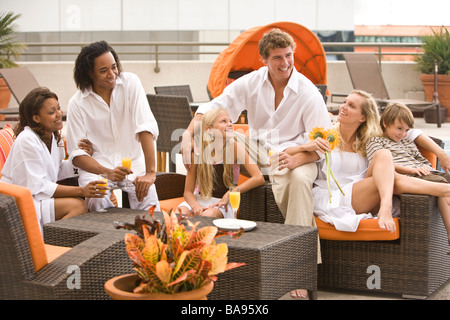 Portrait de la famille et les amis se prélasser près de la piscine sur le toit-terrasse en ville Banque D'Images