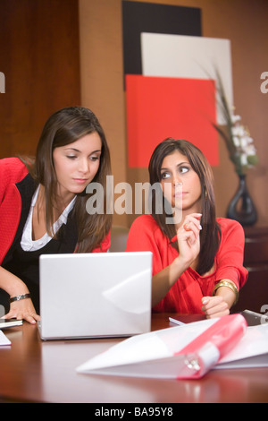 Deux femmes, des employés de bureau qui travaillent ensemble sur l'ordinateur portable dans le marché du travail moderne Banque D'Images