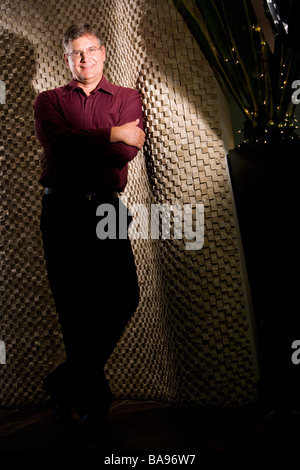 Portrait of smiling young man standing with arms folded Banque D'Images