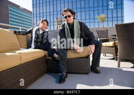 Jeune multi-raciale couple sitting on toit du centre-ville Maison de ville Banque D'Images Jeune multi-raciale couple sitting on toit du centre-ville Maison de ville Banque D'Images