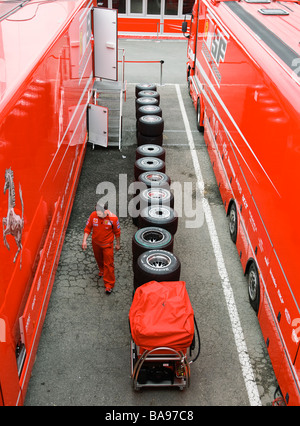 Pneus compétition slick empilés entre les camions de Formule Un Ferrari dans l'enclos Banque D'Images