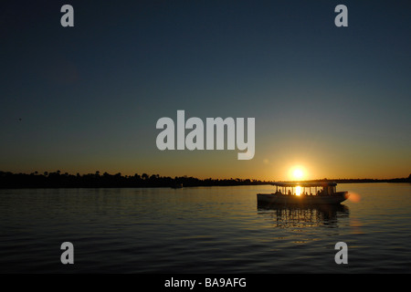 Les touristes à Victoria Falls au Zimbabwe ne peuvent connaître une fois dans sa vie une croisière au coucher du soleil sur le majestueux fleuve Zambèze. Banque D'Images