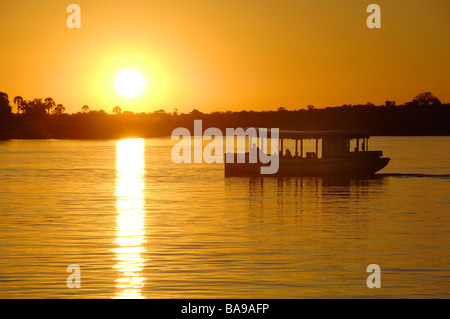 Les touristes à Victoria Falls au Zimbabwe ne peuvent connaître une fois dans sa vie une croisière au coucher du soleil sur le majestueux fleuve Zambèze. Banque D'Images