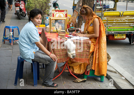 Un hindou fortune teller donnant des conseils à son étal sur près de Maha Uma Devi Temple Hindou Silom Road Bangkok Thaïlande Banque D'Images