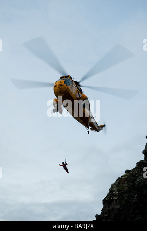 Un hélicoptère Sea King de la RAF Valley le sauvetage d'un jeune homme qui avait perdu sa place sur les falaises à l'ouest du pays de Galles Aberystwyth UK Banque D'Images