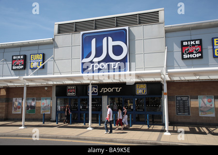 Shoppers en passant par JJB Sports store, Robin Retail Park, Wigan Banque D'Images