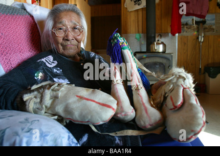 Un aîné des Premières Nations en peau de caribou femelle porte des mitaines dans la collectivité d'Old Crow (Territoire du Yukon, Canada. Banque D'Images