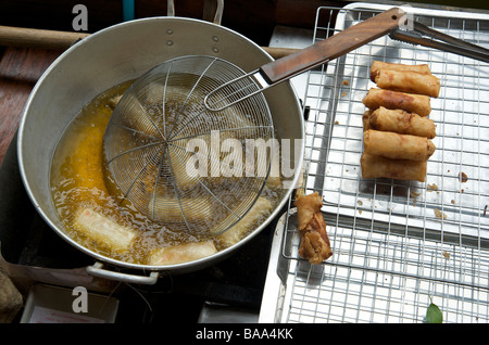 Des rouleaux de printemps la friture dans un wok au marché flottant près de Bangkok en Thaïlande Banque D'Images