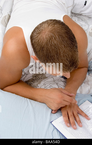 Fit man reading book au repos Banque D'Images