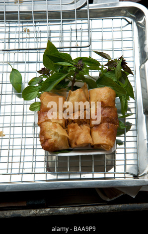 Frites fraîchement préparé des rouleaux de printemps et les feuilles de basilic thaï doux prêt à manger au marché flottant près de Bangkok en Thaïlande Banque D'Images