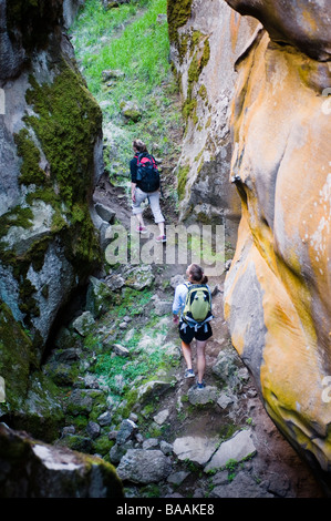 Deux femmes de la randonnée à travers une fissure dans le sol, une fissure volcanique près de la vallée de Noël, de l'Oregon. Banque D'Images