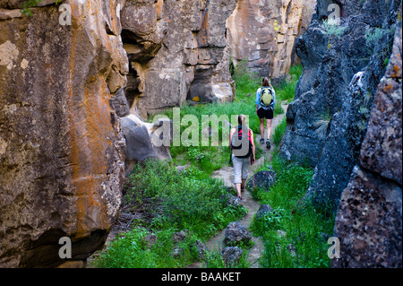 Deux femmes marchent à travers une fissure dans le sol, une fissure volcanique près de christmas Valley, Oregon. Banque D'Images