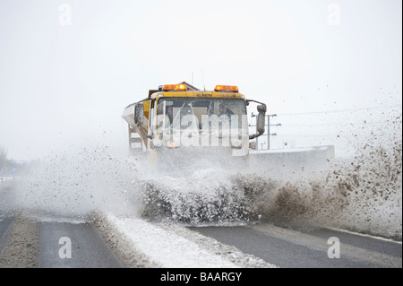 Camion de déneigement saleuses avec montée à l'avant l'effacement de la neige des routes en milieu rural Leicestershire Angleterre Banque D'Images