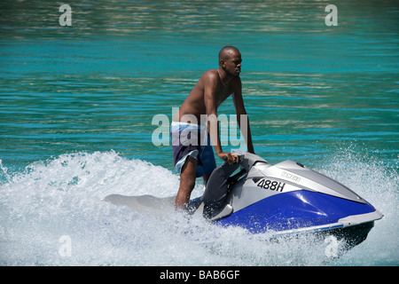 Bajan locale man riding sur un 'Jet Ski ou Motomarine (PWC) dans la côte ouest de la Barbade, "West Indies" Banque D'Images